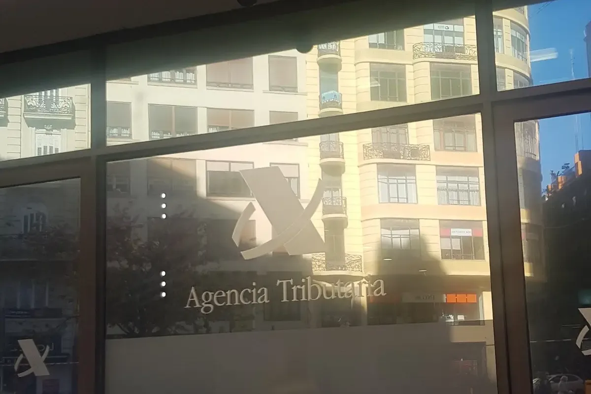 Gläserne Eingangstür eines Büros der Steuerbehörde mit dem Logo der Agencia Tributaria und den Wörtern entrada und salida.