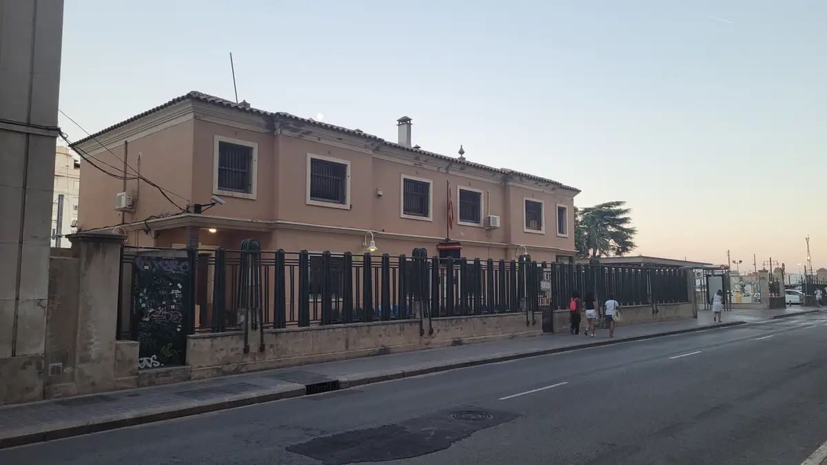 Long low police building behind a railing seen from the street