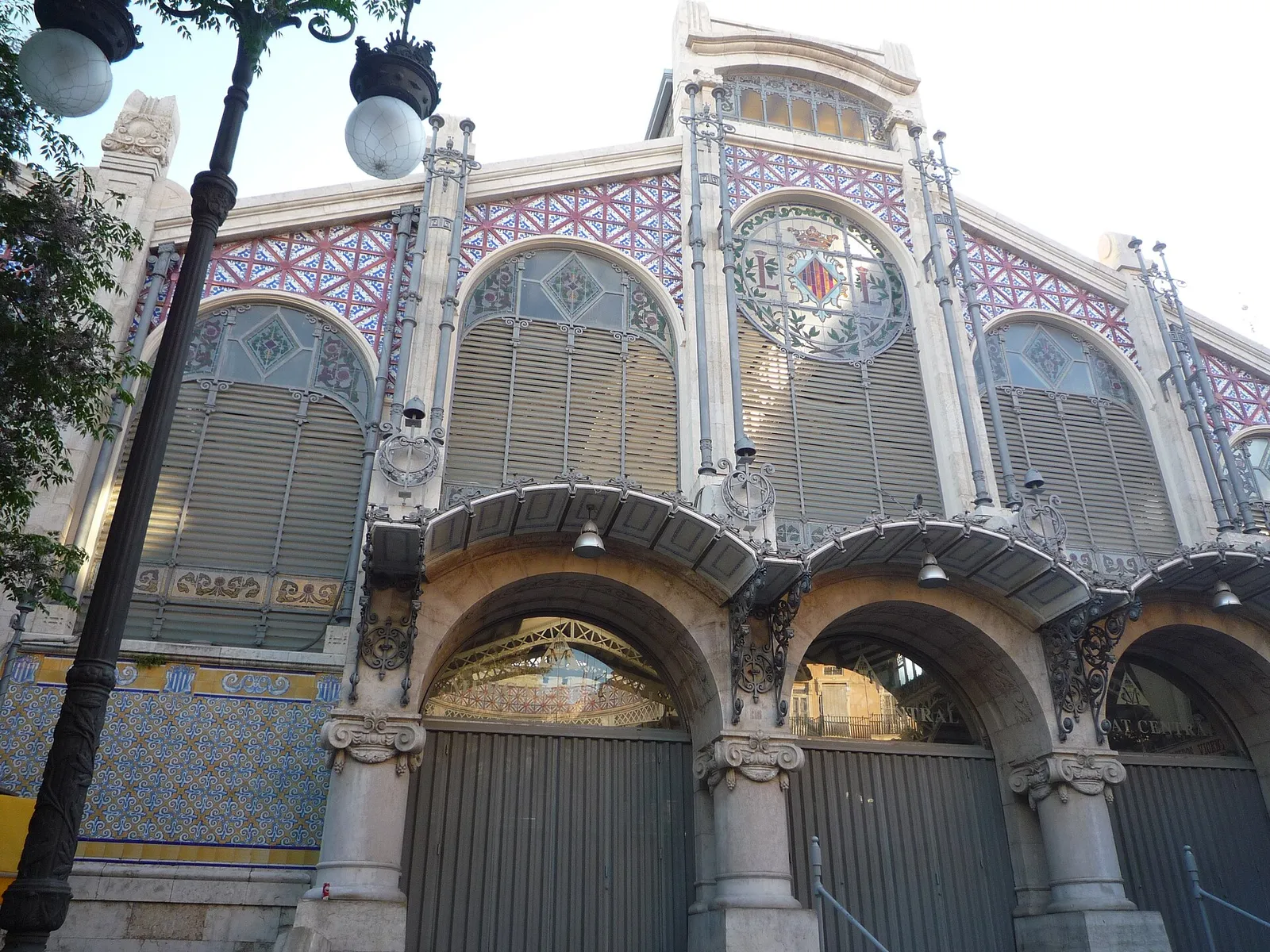 Verzierte Fassade aus Fliesen und Glas einer Markthalle mit Bogeneingängen