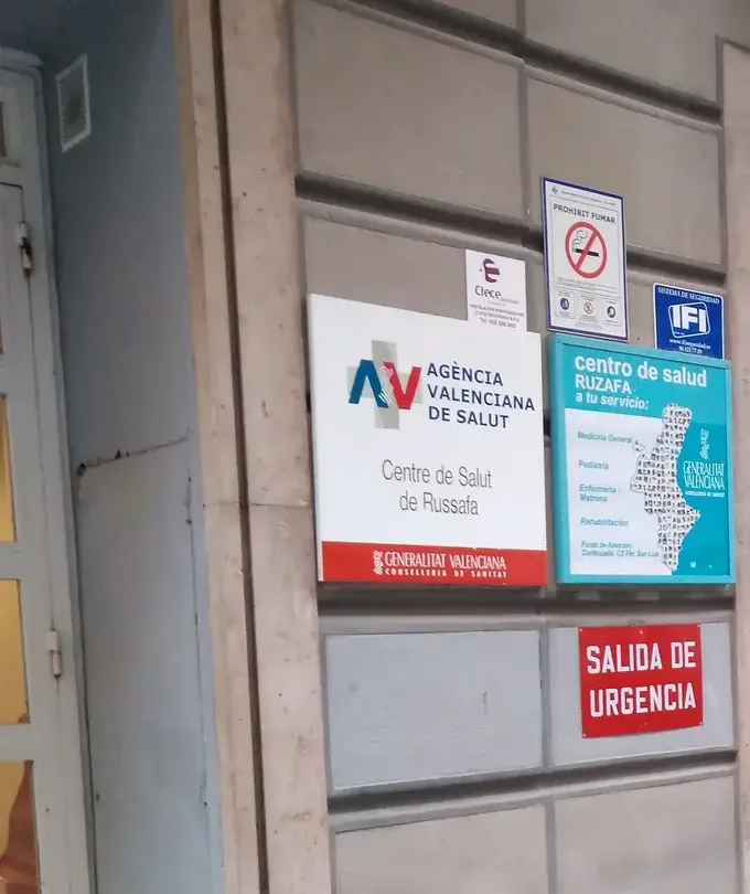 Eingang eines Centro de salud mit dem Schild der regionalen Gesundheitsagentur und dem Schild des Zentrums an der Wand