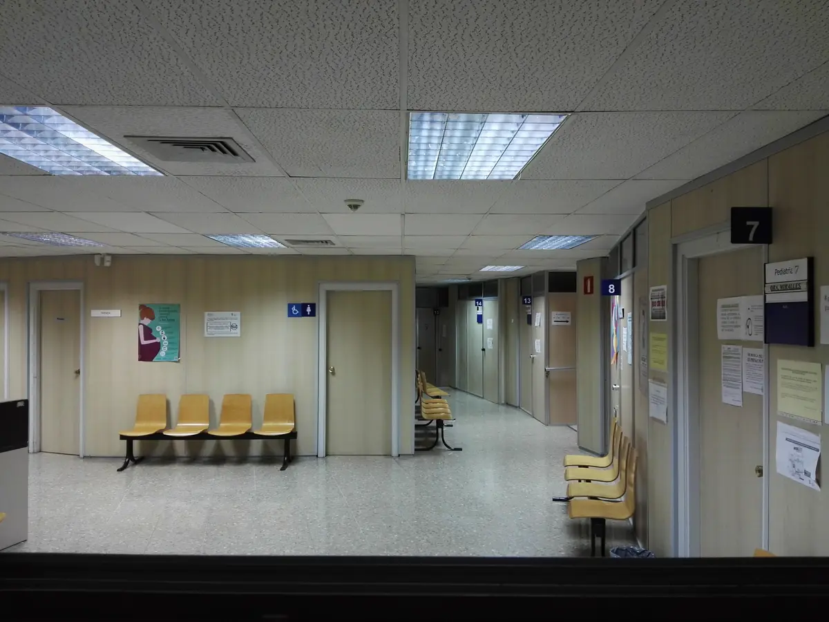 Leerer Wartebereich mit gelben Stühlen an einem Flur in einem Centro de salud