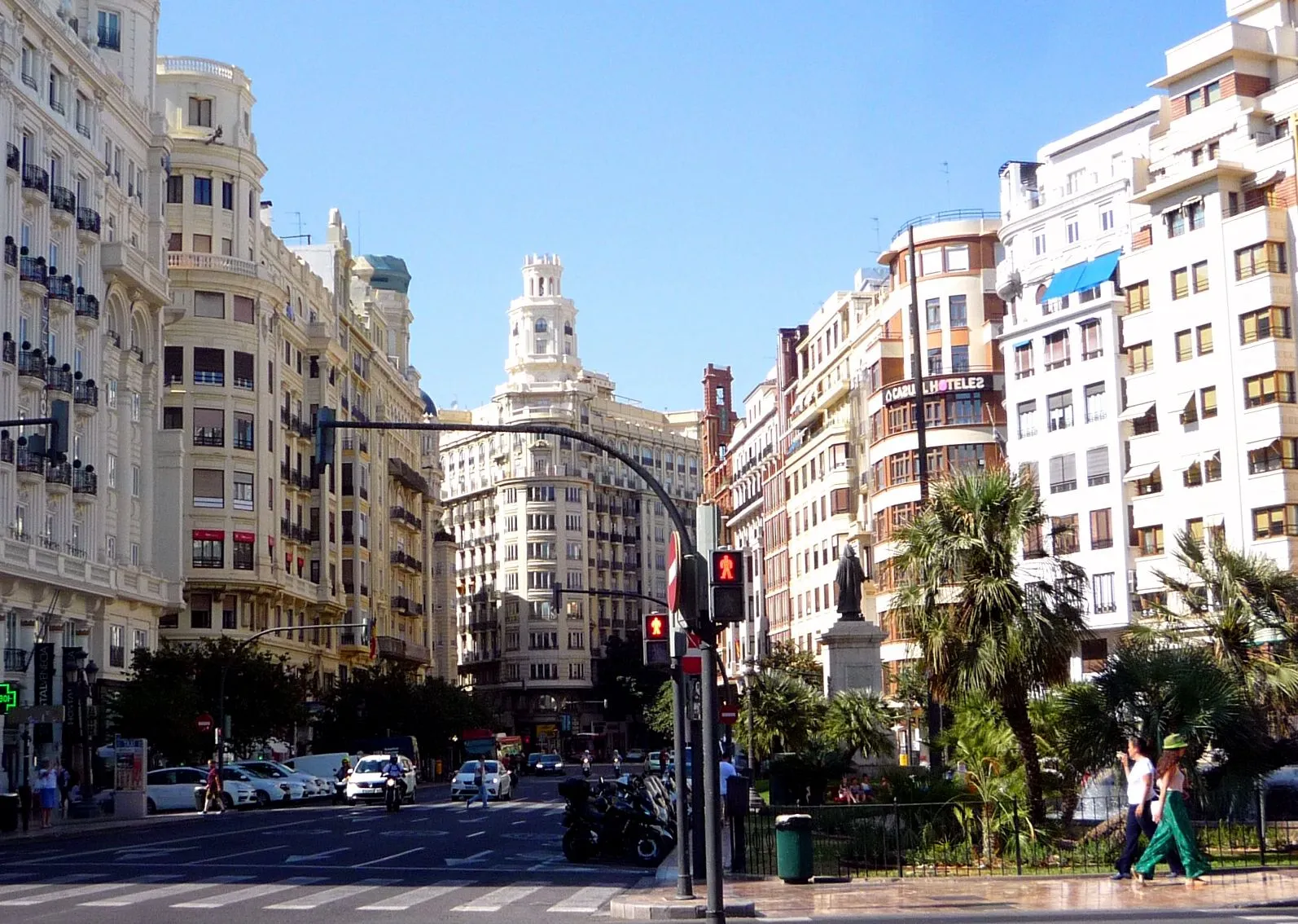 Platz vor dem Rathaus von Valencia, das Rathausgebäude steht hinter Bäumen und einem Brunnen.