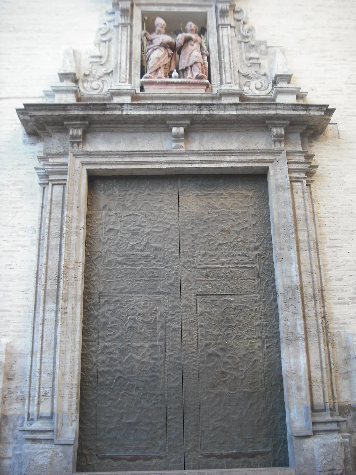 Steinportal mit geschnitzter Einfassung und geschlossenen Holztüren an der Kirche Sant Valero.